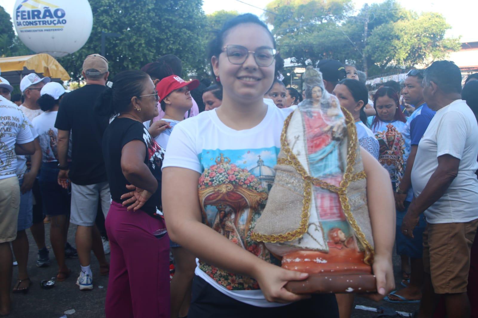 Professora carrega imagem de 7 kg no Círio para agradecer pela saúde da família.